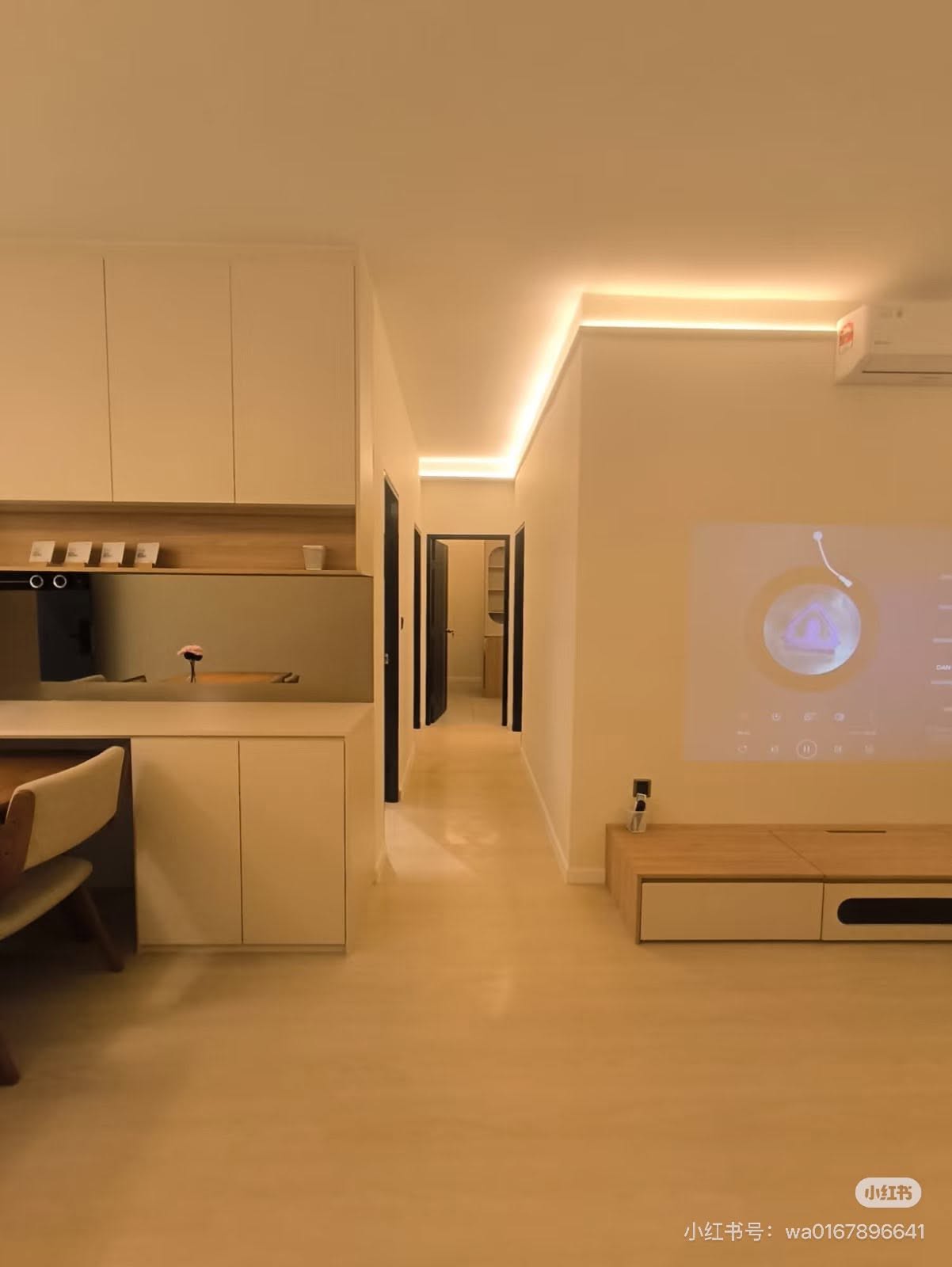 Open living space with cove lighting and projector wall